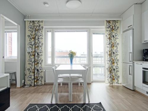 a dining room with a table and a window at Kotimaailma Apartments Oulu in Oulu