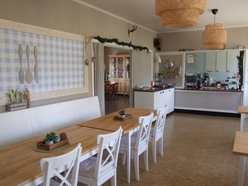 a kitchen and a dining room with a table and chairs at Skålleruds Gård in Åsensbruk