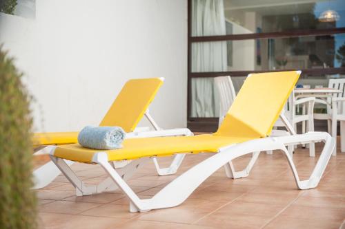 zwei gelbe und weiße Stühle auf einer Veranda in der Unterkunft Oiza Garden at Alcudia beach with WIFI and AACC, BahiaBlanca in Alcúdia
