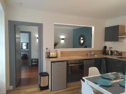 a kitchen with a sink and a table and a mirror at Le Gambetta in Poitiers