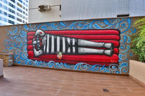 a wall with a painting of a hand holding a phone at Radisson RED Campinas in Campinas