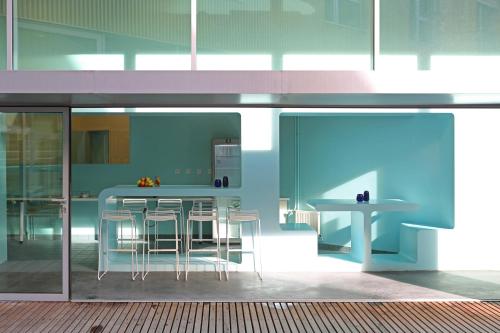eine blaue Küche mit einer Theke und Stühlen in der Unterkunft Auberge de Jeunesse HI Lille in Lille