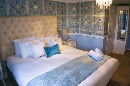 a bed with a white comforter and pillows in a bedroom at Seacrest Hotel in Portsmouth