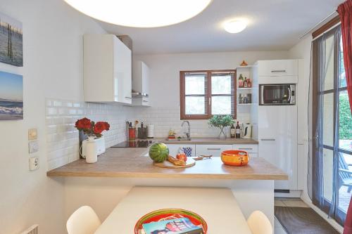 a kitchen with white cabinets and a counter with vegetables on it at Résidence Château de Salles in Salles