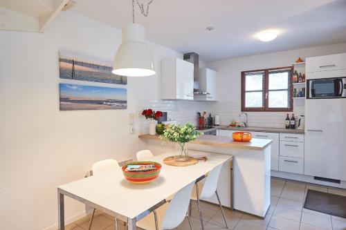 a white kitchen with a table and chairs and a counter at Résidence Château de Salles in Salles