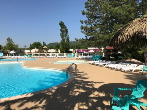 a swimming pool with lounge chairs and a resort at Camping Officiel Siblu Les Rives de Condrieu in Condrieu