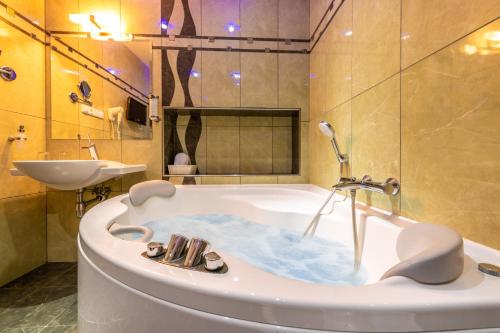 a bathroom with a bath tub and a sink at Danubia Gate Hotel in Bratislava