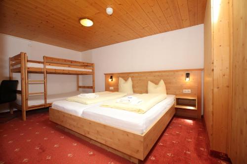 a bedroom with a bed and a bunk bed at T3 Alpenhotel Garfrescha in Sankt Gallenkirch