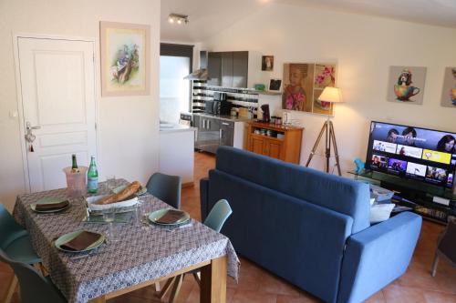 - un salon avec un canapé bleu et une table dans l'établissement Chez Meli et Jo, à Falaise
