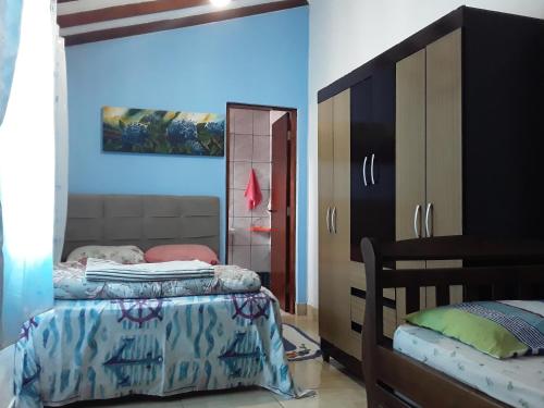 1 dormitorio con 2 camas y espejo en Hostel do Enzo en Itanhaém