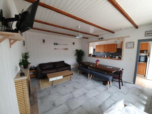 un salon avec un canapé et une table dans l'établissement Grande maison proche mer, à Tréveneuc