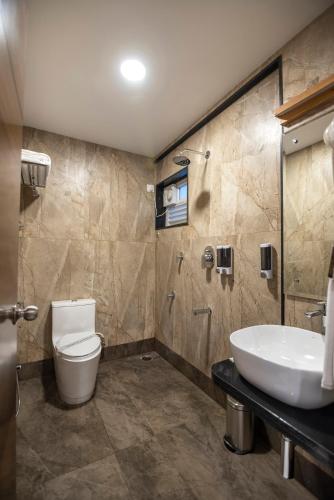 a bathroom with a toilet and a sink at Vanusa Residency in Bengaluru