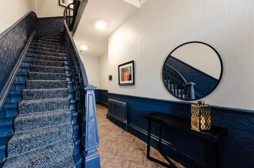 a staircase with a mirror on the wall and a mirror at Sweeney Motherwell in Motherwell
