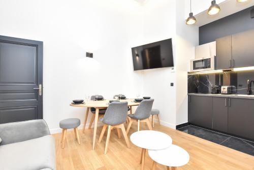 une cuisine et une salle à manger avec une table et des chaises dans l'établissement Cosy apartment - 2BR-7P - Arc de Triomphe, à Paris