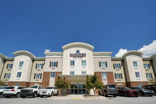 un grande edificio con auto parcheggiate in un parcheggio di Candlewood Suites Columbus-Northeast by IHG a Columbus