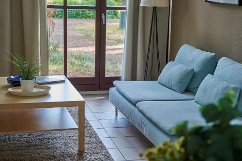 a living room with a blue couch and a table at Résidence Château de Salles in Salles