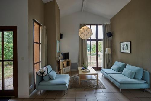 a living room with two blue couches and a table at Résidence Château de Salles in Salles