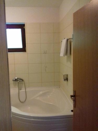a bath tub in a bathroom with a window at Street View Apartman in Fojnica
