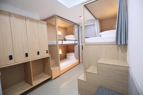 Habitación pequeña con armarios de madera y cama en 杭州武林国际城市营地 en Hangzhou