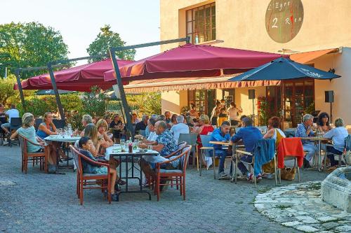 a group of people sitting at tables outside a restaurant at Résidence Château de Salles in Salles