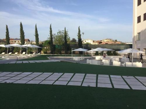 a patio with white umbrellas and tables and chairs at Park Hotel Villamaria in Pavona