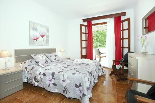 een slaapkamer met een bed met een bloemenbed bij Villa ROTGER in Pollença