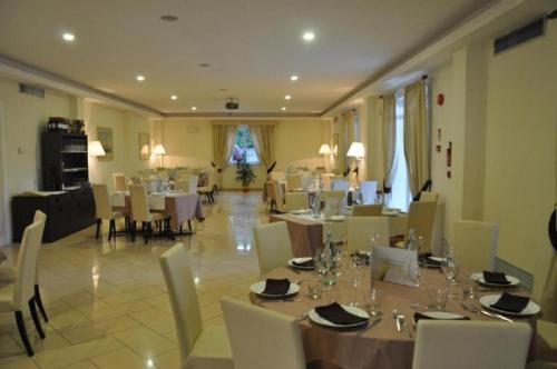 Park Hotel Villamaria في Pavona: غرفة طعام مع طاولات وكراسي في غرفة