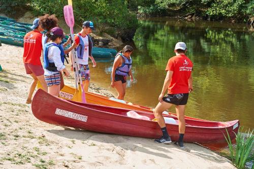 a group of people standing around a boat on the beach at Résidence Château de Salles in Salles