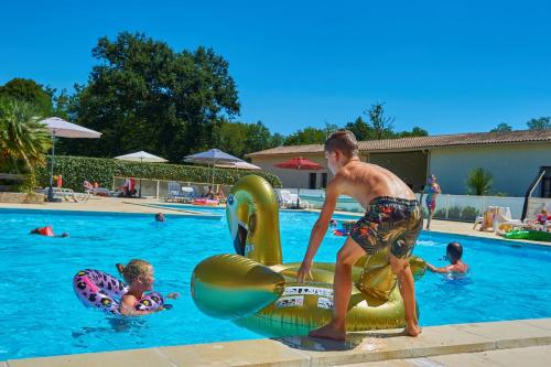a young man playing in a swimming pool at Résidence Château de Salles in Salles