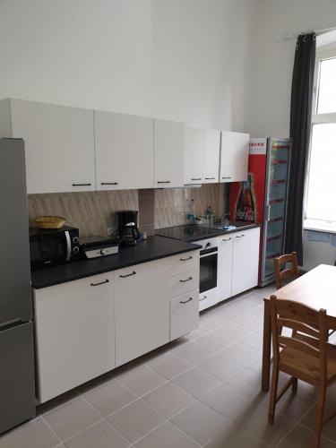 a white kitchen with white cabinets and a table and a tableablish at Mir hostel in Berlin