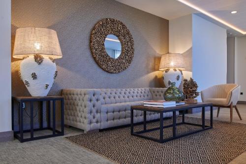 a living room with a couch and a mirror at Ansares Hotel in Tarancón