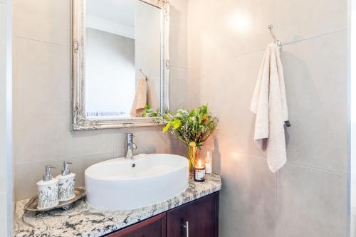a bathroom with a white sink and a mirror at Adato Guesthouse in Potchefstroom