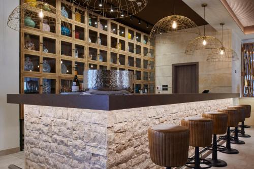 a bar in a restaurant with stools and chandeliers at Ansares Hotel in Tarancón