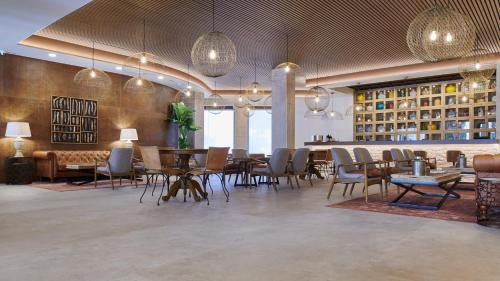 a dining room with tables and chairs and pendant lights at Ansares Hotel in Tarancón