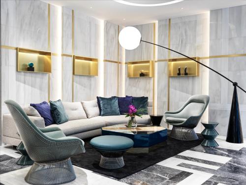 a living room with a couch and two chairs at Athens Capital Center Hotel - MGallery Collection in Athens