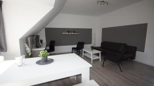 ein Wohnzimmer mit schwarzen Stühlen und einem weißen Tisch in der Unterkunft Appartementhaus Beckergrube in Lübeck
