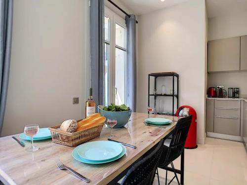 une table en bois avec des assiettes et des verres à vin dessus dans l'établissement ☆ SILVER BEACH ☆, à Nice