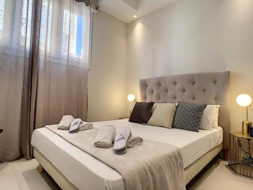 - une chambre blanche avec un grand lit et des serviettes dans l'établissement ☆ SILVER BEACH ☆, à Nice