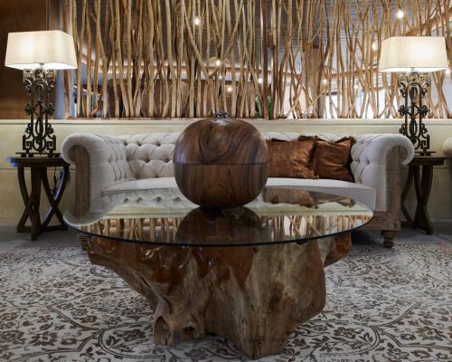a living room with a couch and a tree stump coffee table at Ansares Hotel in Tarancón