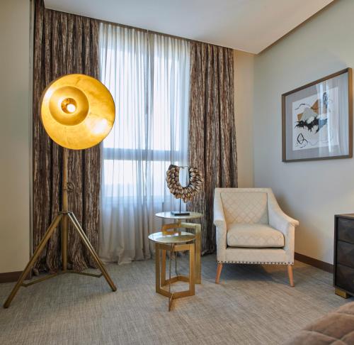 a living room with a chair and a large window at Ansares Hotel in Tarancón