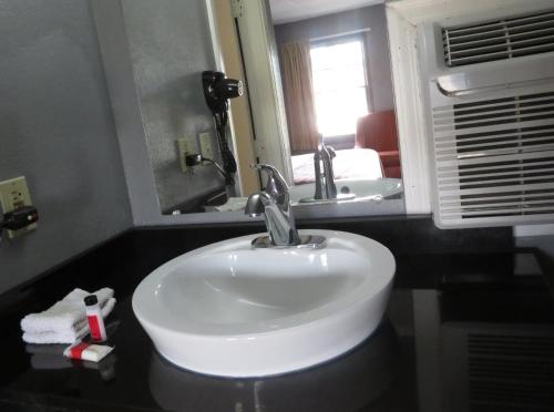 a bathroom with a white sink and a mirror at Travelodge by Wyndham Walterboro in Walterboro
