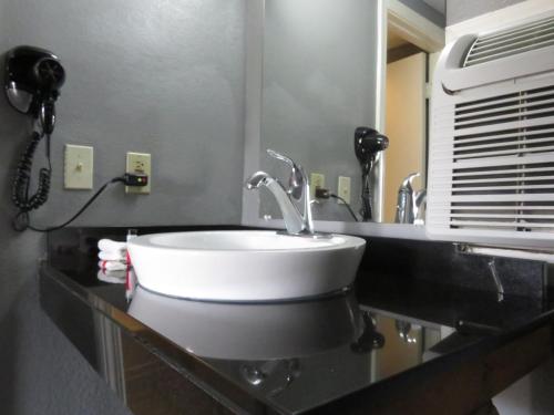 a bathroom with a sink and a phone on a counter at Travelodge by Wyndham Walterboro in Walterboro