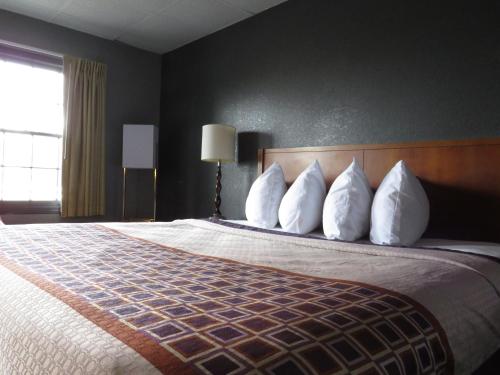 a hotel room with a large bed with white pillows at Travelodge by Wyndham Walterboro in Walterboro