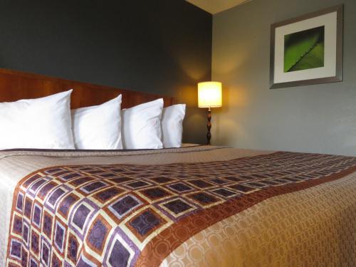 a hotel room with a bed with white pillows at Travelodge by Wyndham Walterboro in Walterboro
