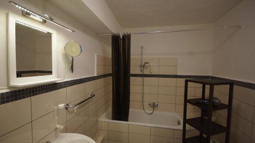 a bathroom with a toilet and a tub and a sink at Appartementhaus Obertrave in Lübeck