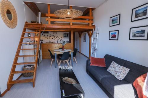 un salon avec un lit mezzanine et un canapé dans l'établissement ROYALEMENT BIEN ! Hyper-centre - Wifi - Netflix - Disney plus, à Annecy