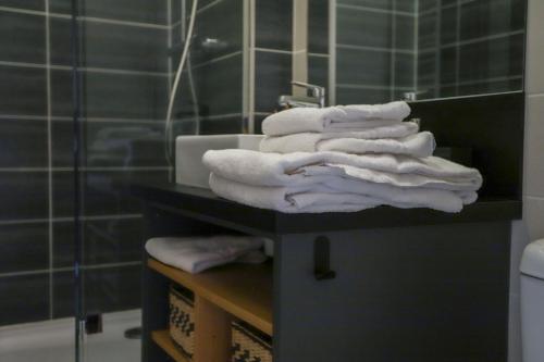 - une pile de serviettes sur un comptoir dans la salle de bains dans l'établissement ROYALEMENT BIEN ! Hyper-centre - Wifi - Netflix - Disney plus, à Annecy