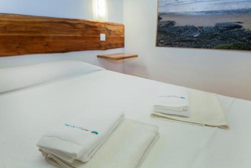 1 dormitorio con 1 cama con 2 toallas en H - Montes de Praias GuestHouse, en Aljezur