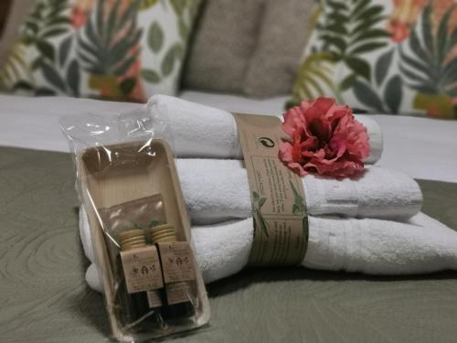 a pile of towels and a flower on a bed at Casa dos arcos in Sober