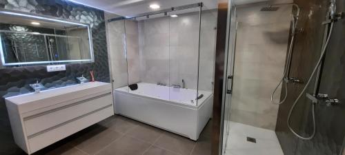 a bathroom with a shower and a tub and a sink at Casa dos arcos in Sober